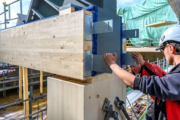 Hightech Kombination aus Stahlträgern und Holz. Präzisionsarbeit auf der Baustelle